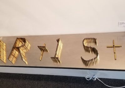 AR15 ARTIST spent Reming 233.cartrages freestanding on stainless steel shelves spelling different words from different perspectives.